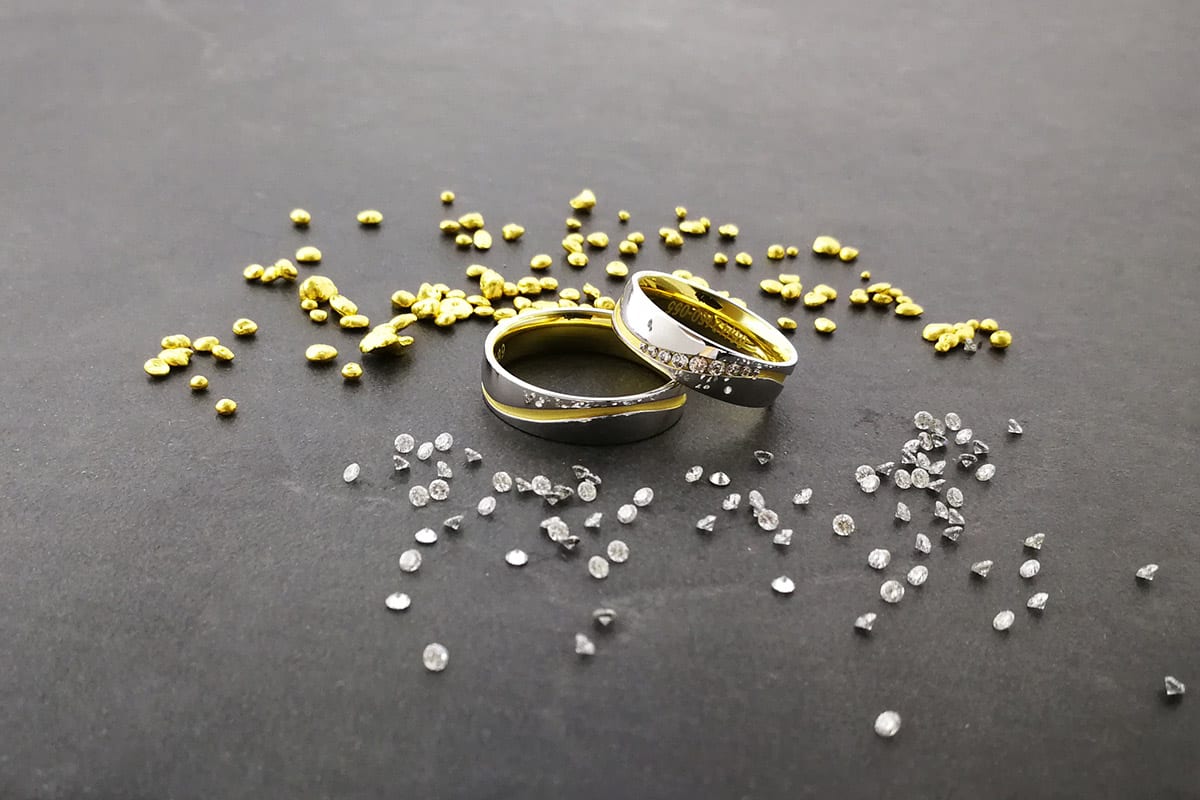 Moderne Eheringe in Bicolor Gelbgold-Weißgold auf einer Schieferplatte