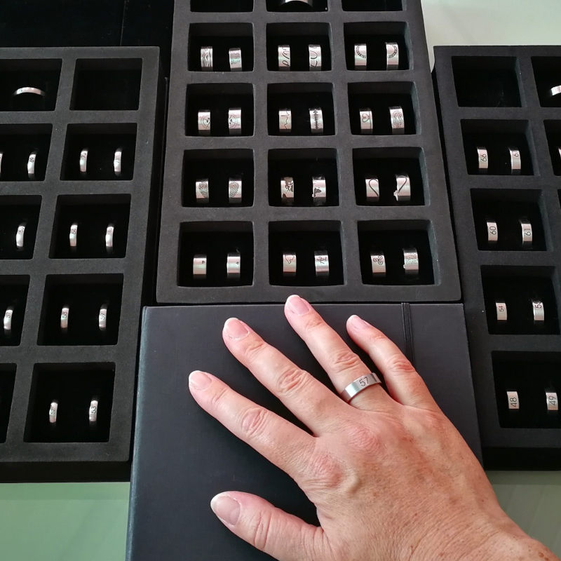 Auswahl an Größenmusterringen und eine Hand mit Musterring